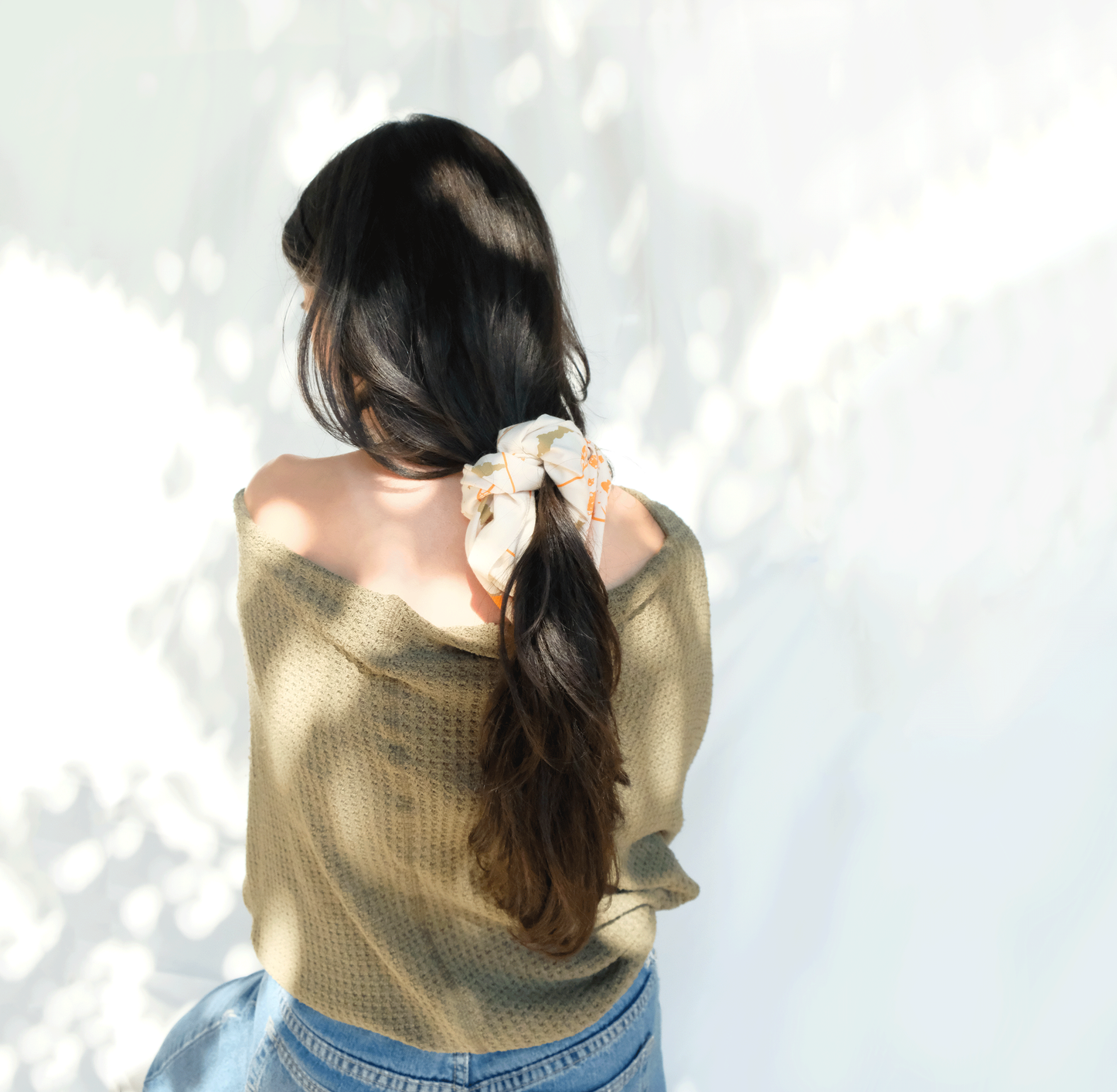 Woman wearing the fields bandana wrapped like a scrunchie in her hair