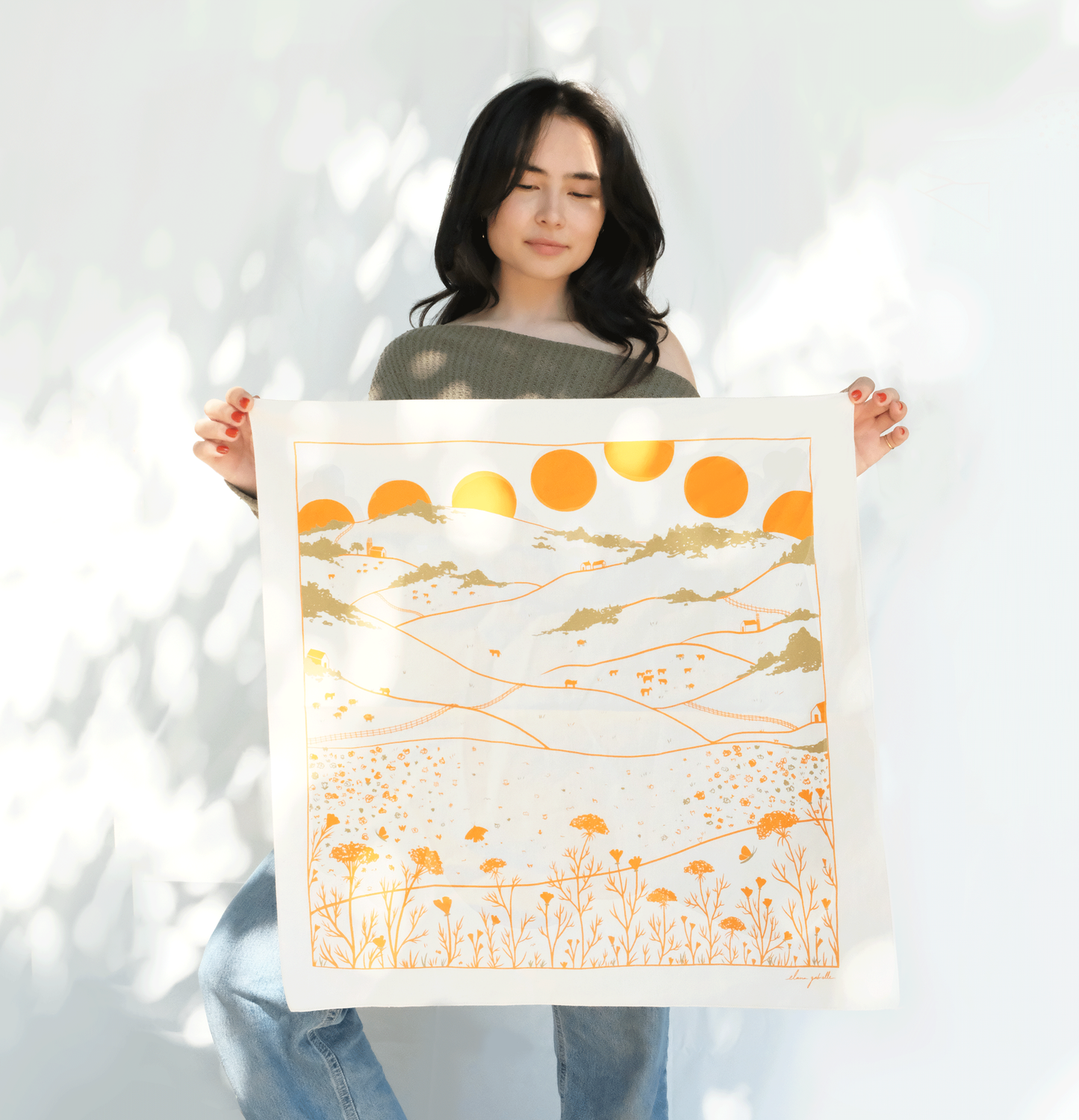 Woman with long dark hair holding screen printed bandana 