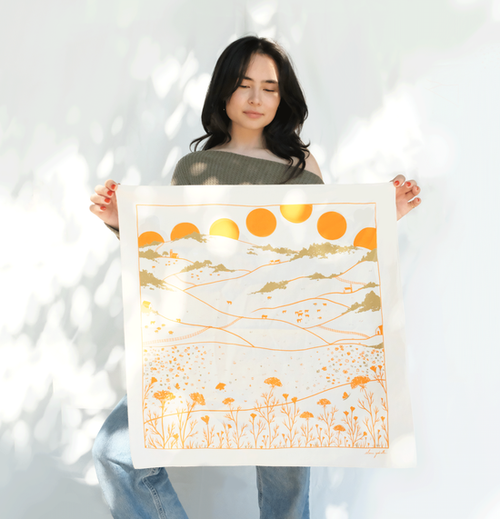 Woman with long dark hair holding screen printed bandana 